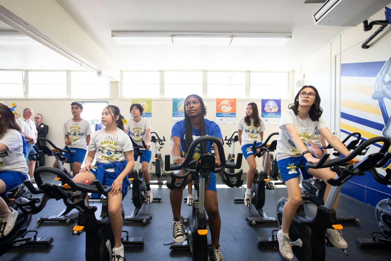 中学生在新健身房里骑健身自行车