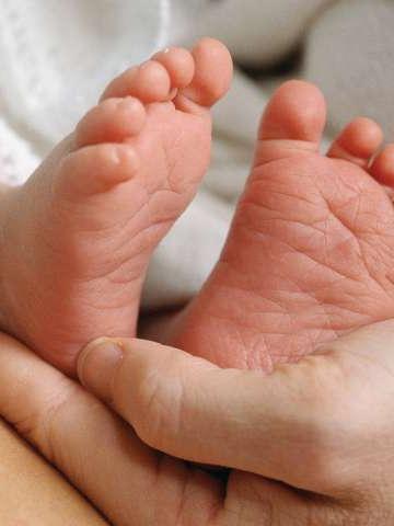 大人的手握着婴儿的脚